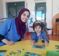 The story-teller Samah plays with 3-year-old Wafa