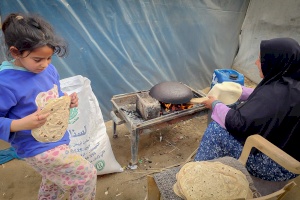 Mother Baking Bread on a Traditional Stove to Feed Her Children